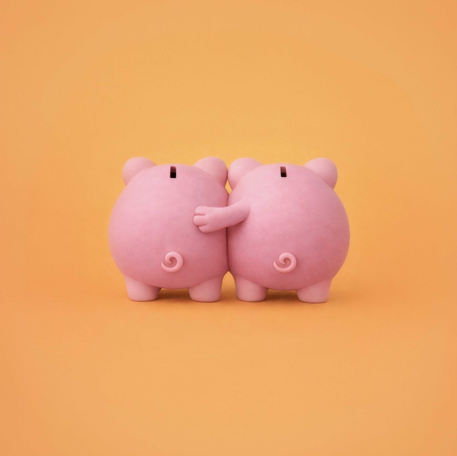 Two piggy banks embracing